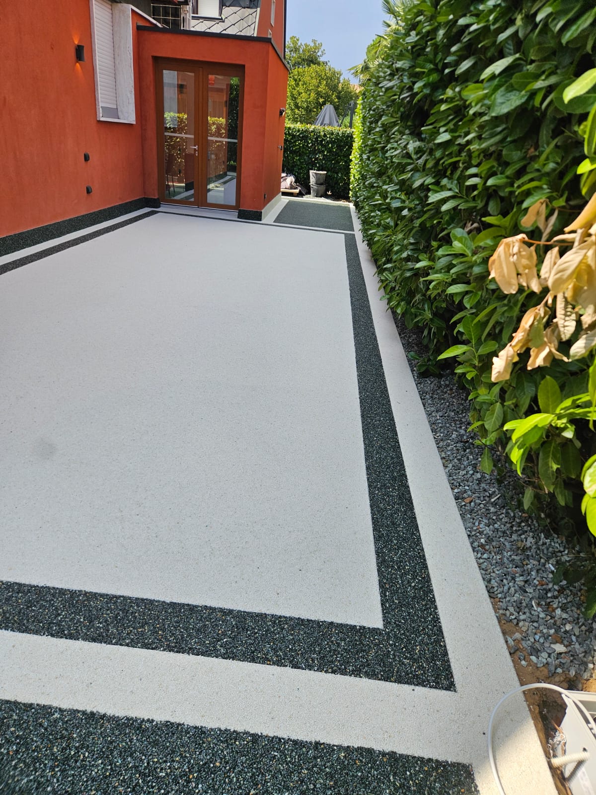 Cortile esterno in graniglia bianca con doppia cornice scura
