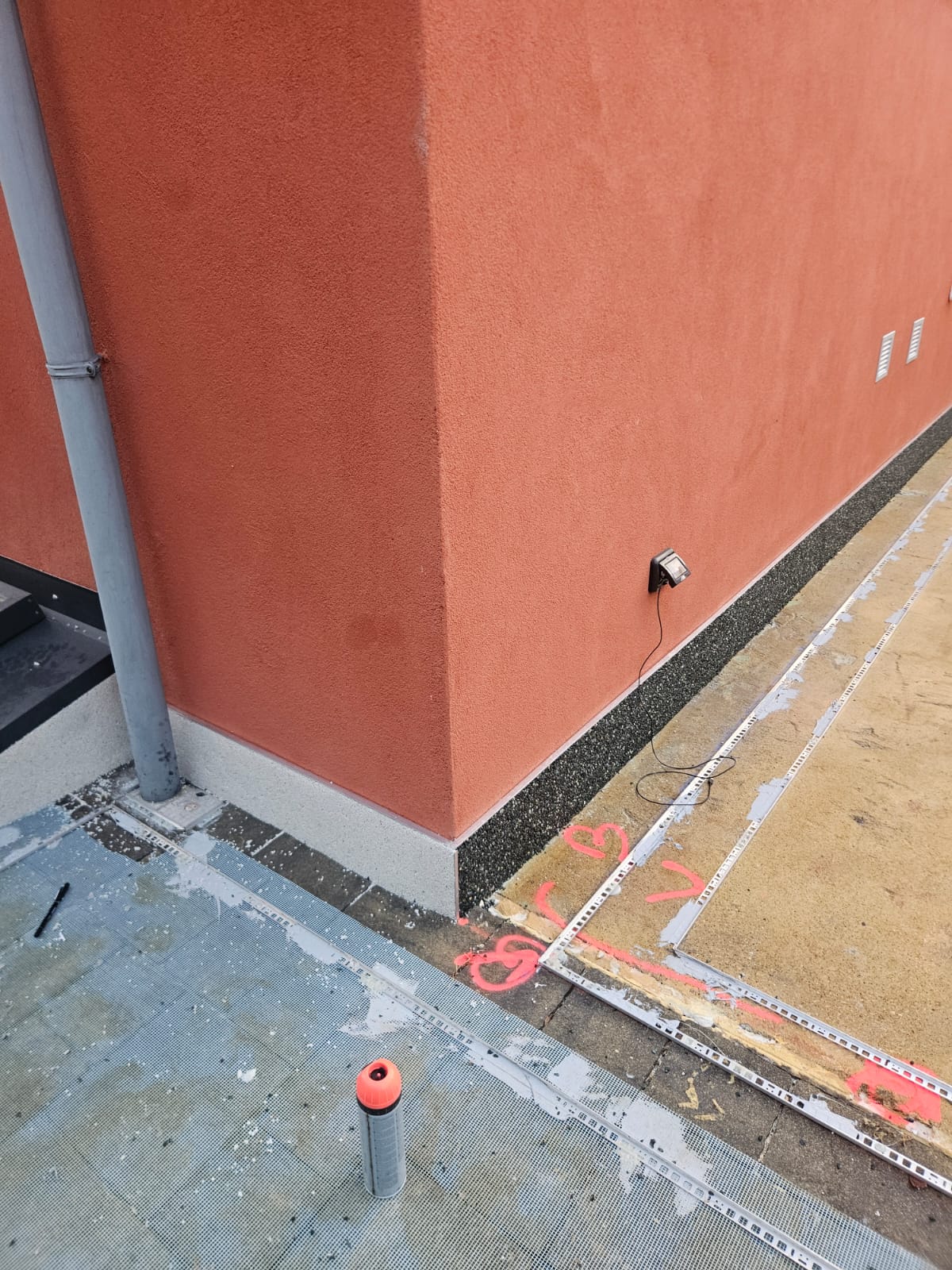 Battiscopa esterno in graniglia nera lungo la parete