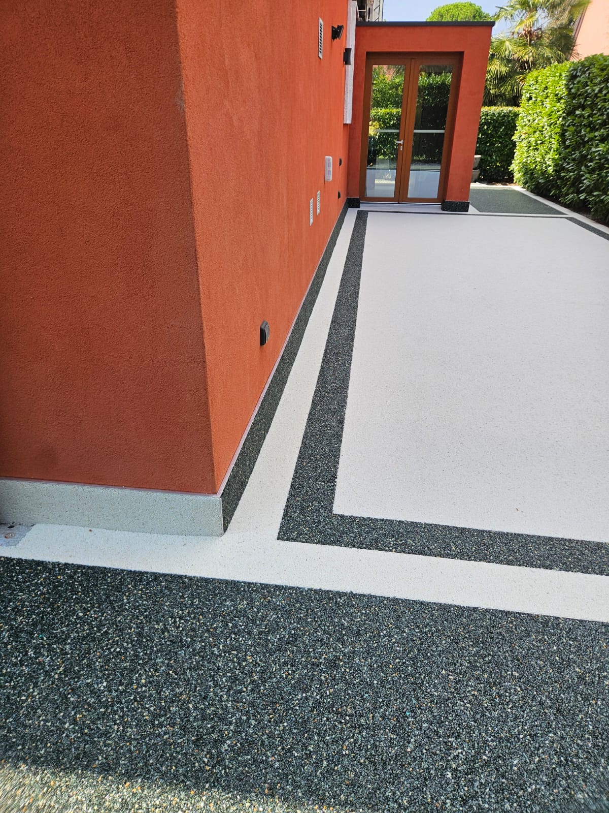 Terrazza in graniglia chiara con fasce nere e bordi in tinta